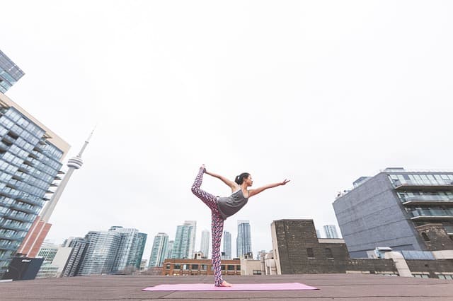 Healthy woman performing yoga in a city square